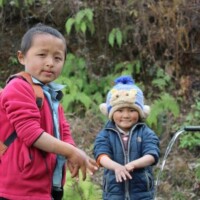 Two boys washing hands with tap